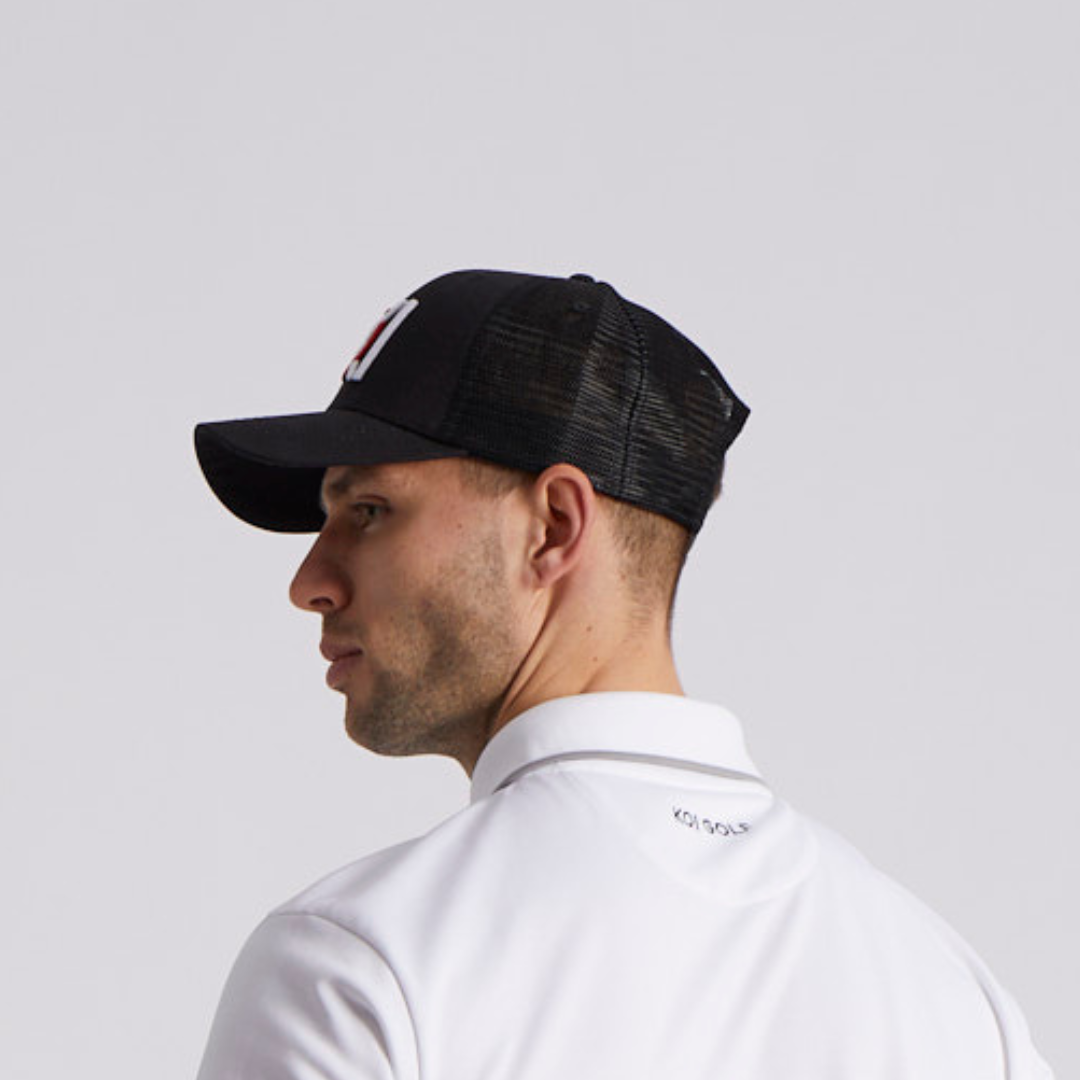 Man wearing a black cap and white shirt on a light gray background