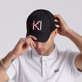 Man wearing a black golf cap with a logo, white shirt, and white background