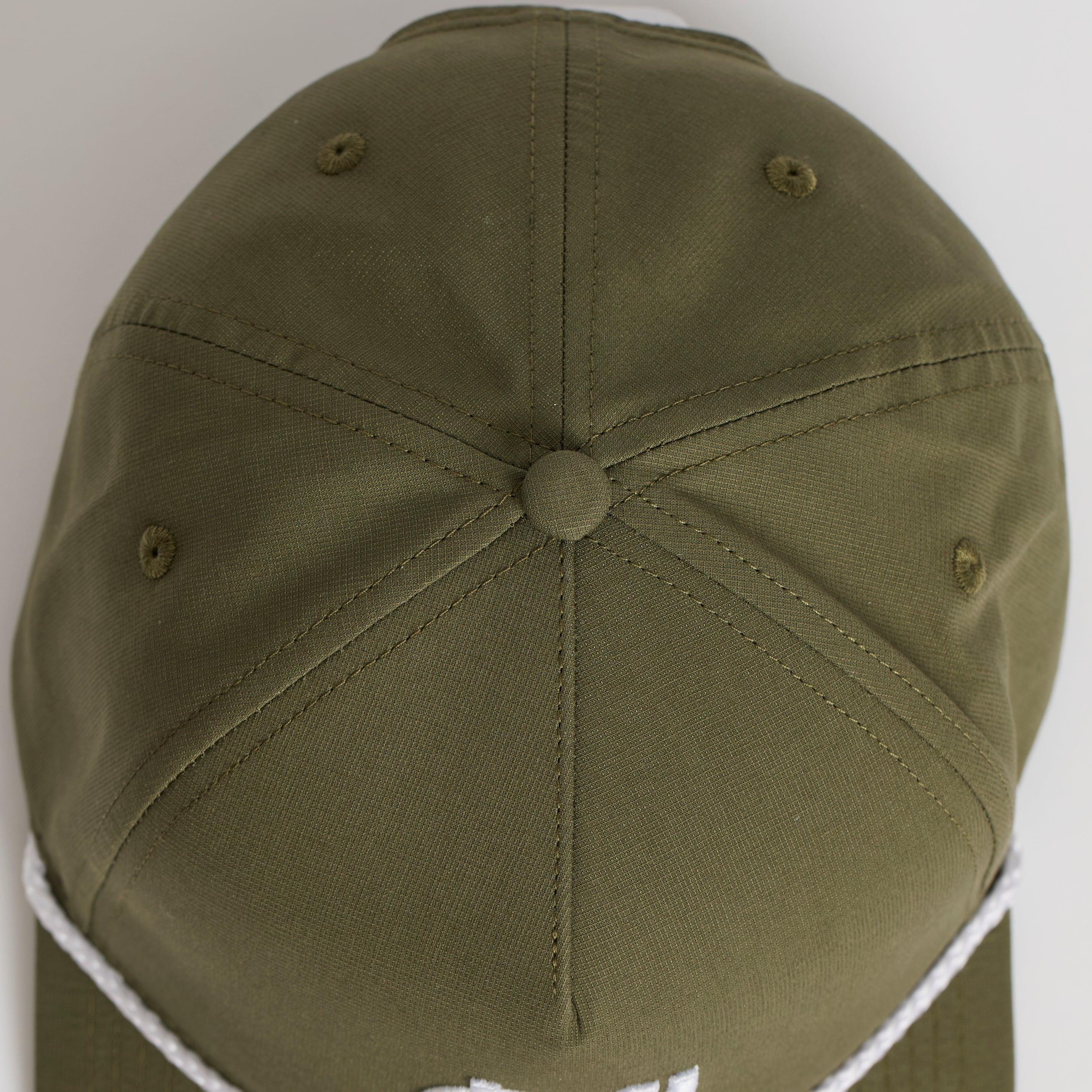 Green cap with white rim and logo on a light gray background