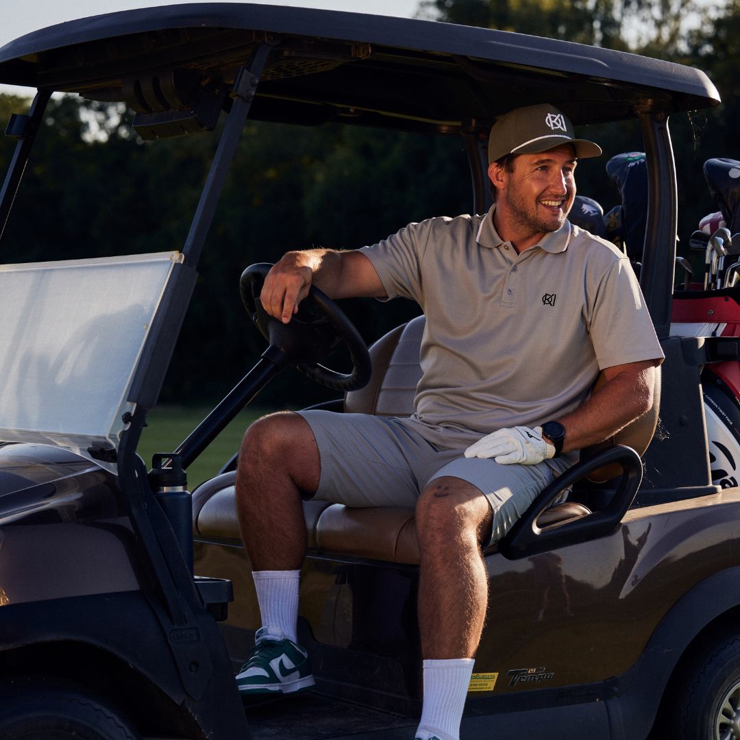 Man sitting in a golf cart on a golf course