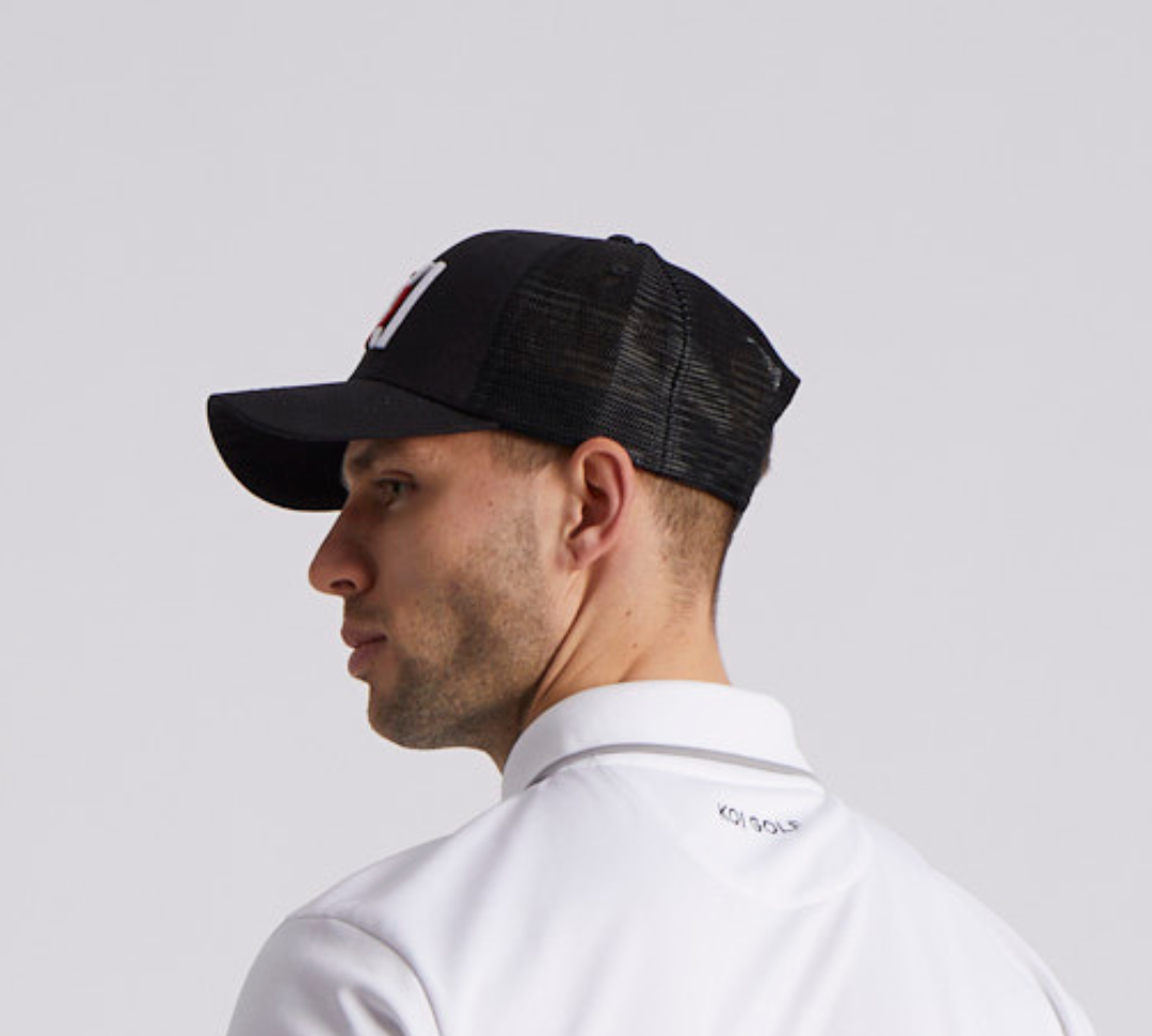 Man wearing a black cap and white shirt on a light gray background