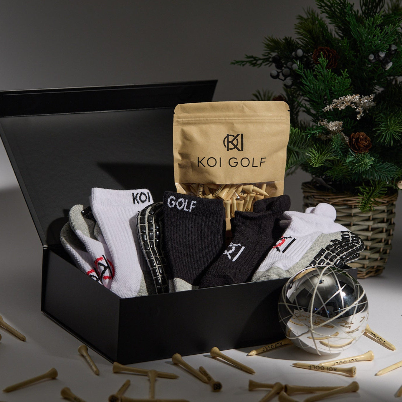 Box of Koi Golf products with a Christmas tree in the background