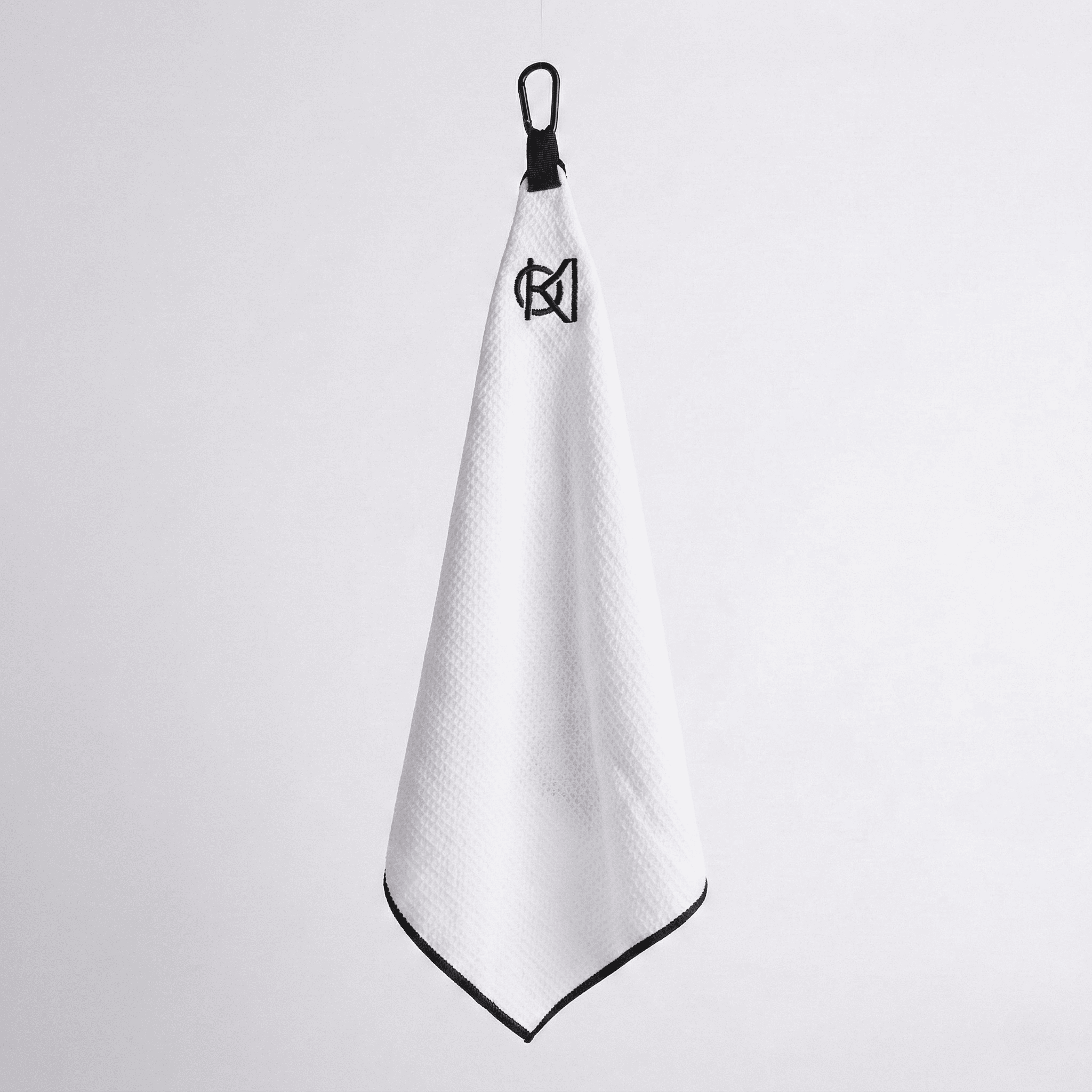 White towel with black trim and logo on a light gray background