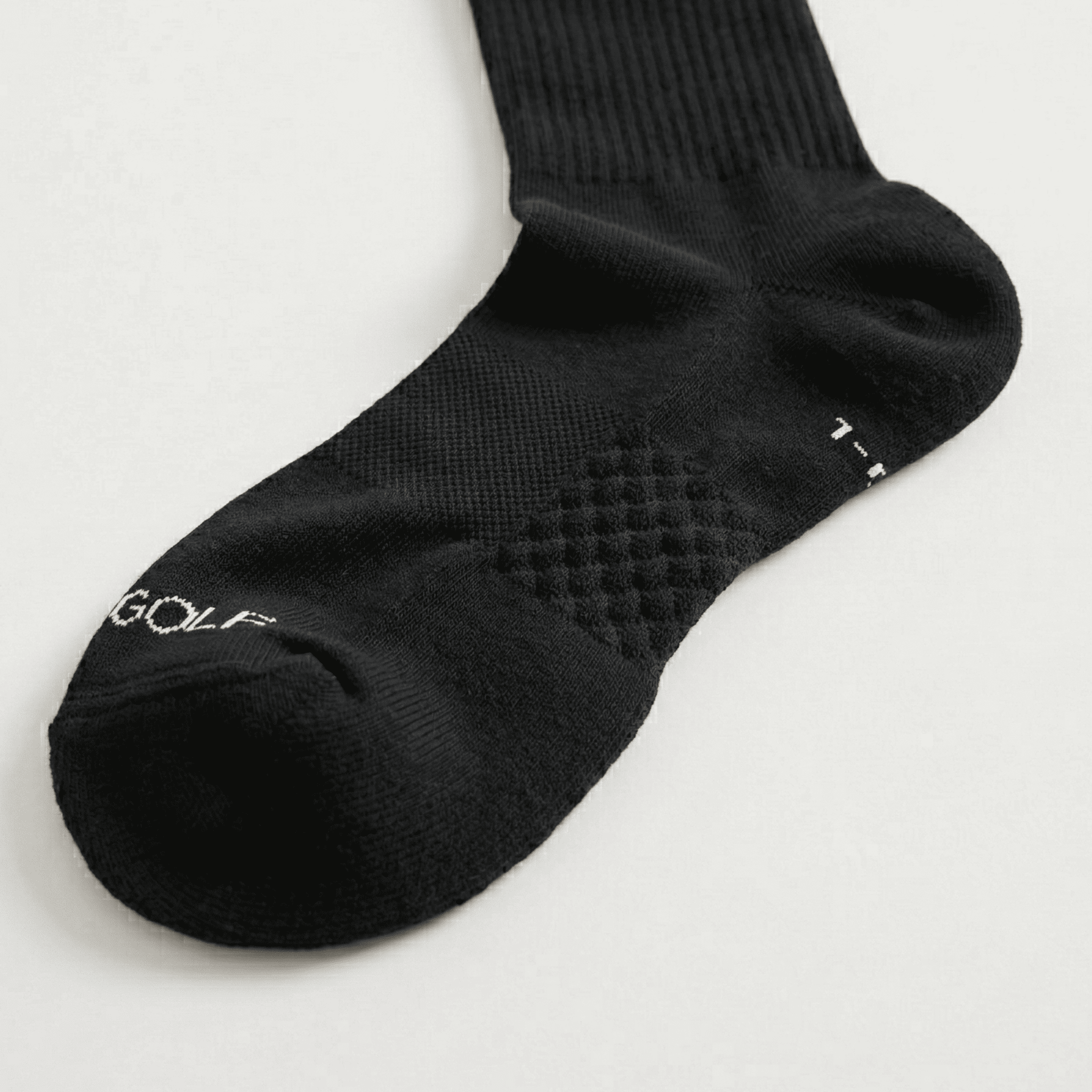 Black sock with textured sole on a light gray background